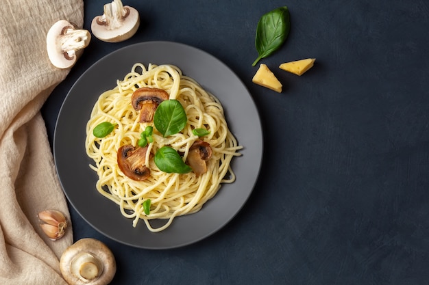 Pâtes aux champignons avec du fromage sur un espace bleu foncé