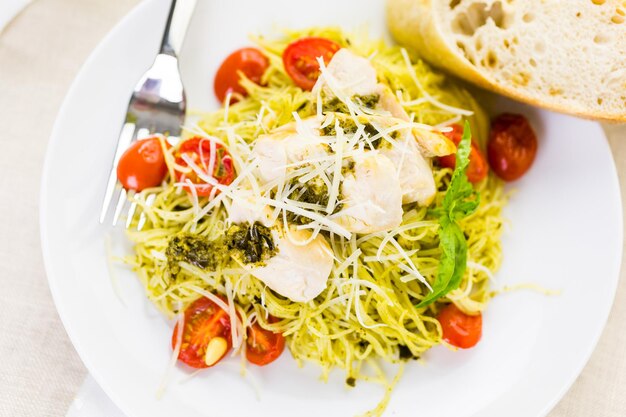 Pâtes aux cheveux d'ange maison avec sauce pesto, tomates cerises rôties et poulet grillé.