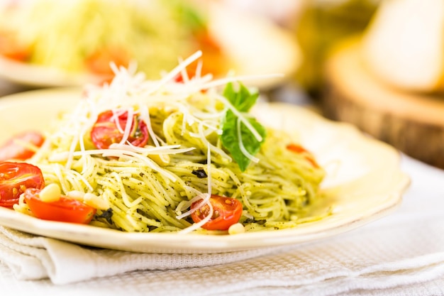 Pâtes aux cheveux d'ange maison avec sauce pesto et tomates cerises rôties.