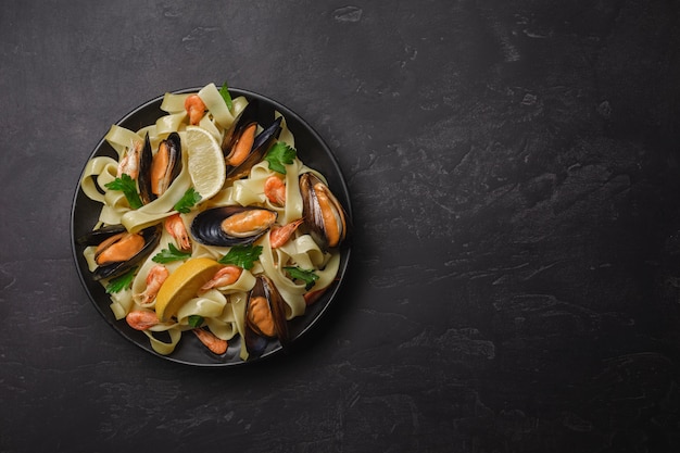 Pâtes aux fruits de mer sur la table en pierre. Moules et crevettes. Vue de dessus avec espace de copie.