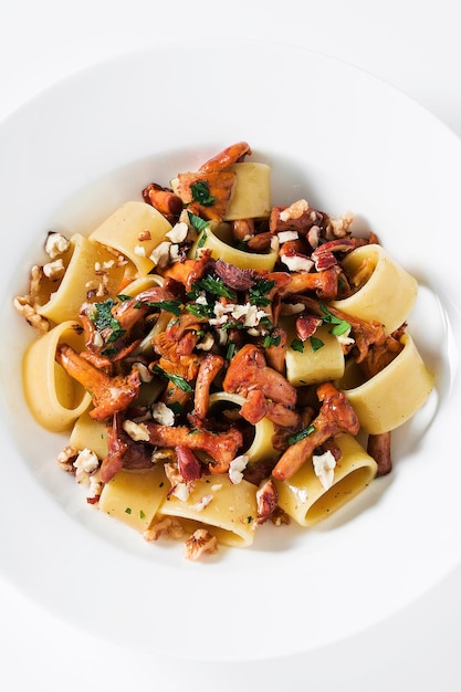 Pâtes aux girolles dans une assiette sur la table