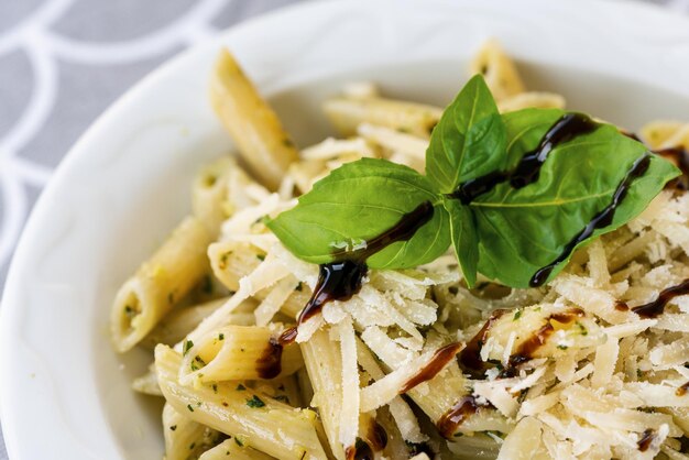 Pâtes aux légumes Parmesan et sauce crémeuse dans un bol sur fond de table Vue de dessus