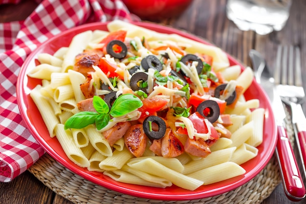 Pâtes aux olives, tomates sur une assiette