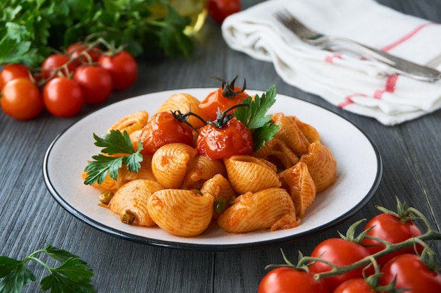 Pâtes aux petits pois et tomates cerises au four sur une assiette