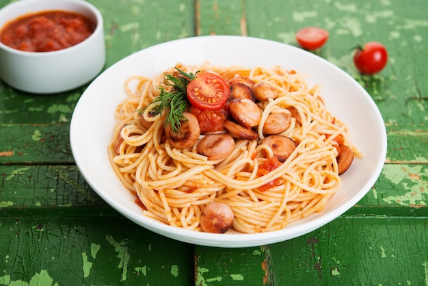 Pâtes aux saucisses et sauce tomate sur fond rustique, gros plan