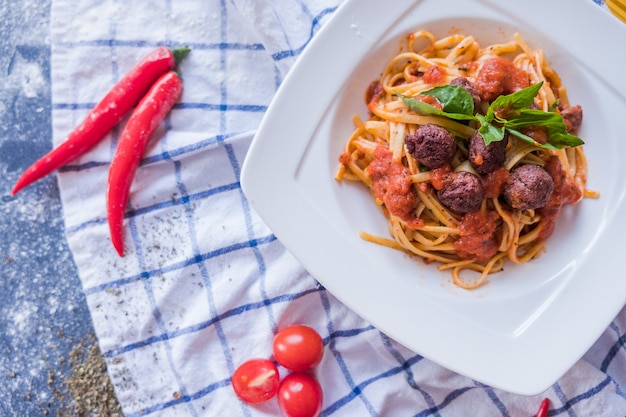 Pâtes Bolognaises sur assiette blanche. Spaghetti sur fond bleu