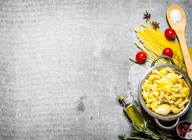 Pâtes bouillies dans la poêle avec de l'huile d'olive et des tomates.