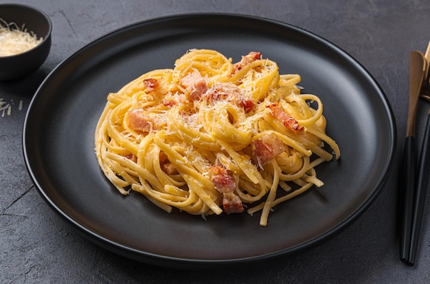 Pâtes à la carbonara avec bacon, fromage et œuf sur fond sombre Vue latérale agrandi