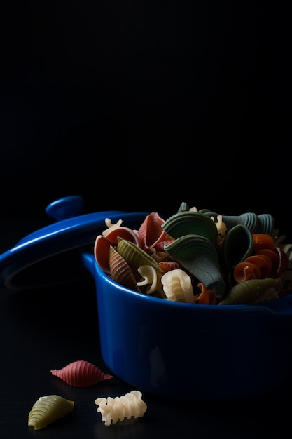 Pâtes colorées à l&#39;épeautre dans un pot en céramique bleu