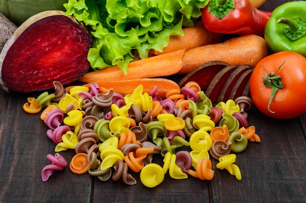 Photo pâtes colorées sur une table en bois rustique sombre