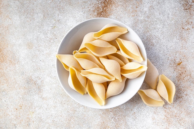 Pâtes Conchiglie cru grosse coquille farine de semoule de blé dur repas sain collation alimentaire sur la table