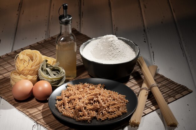 Pâtes crues aux œufs et à l'huile sur la table