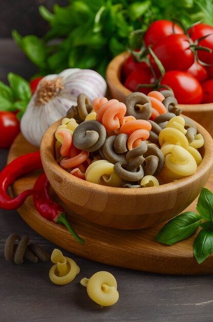 Pâtes crues avec tomates cerises fraîches, basilic, piment rouge et ail pour la cuisine italienne.