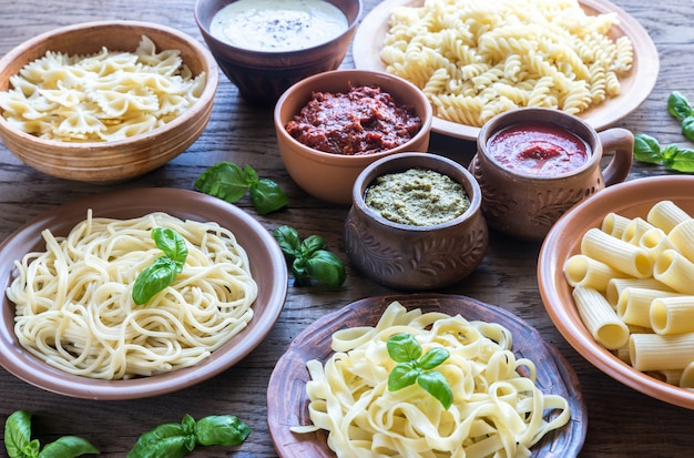 Pâtes avec différentes sortes de sauce sur bois