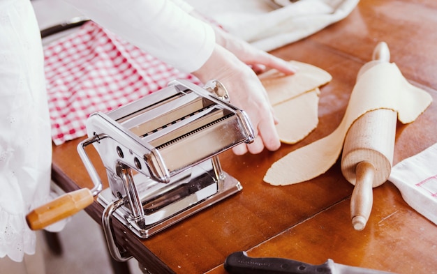 Pâtes faites à la main avec machine à pâtes maker.Woman chef cuisinier