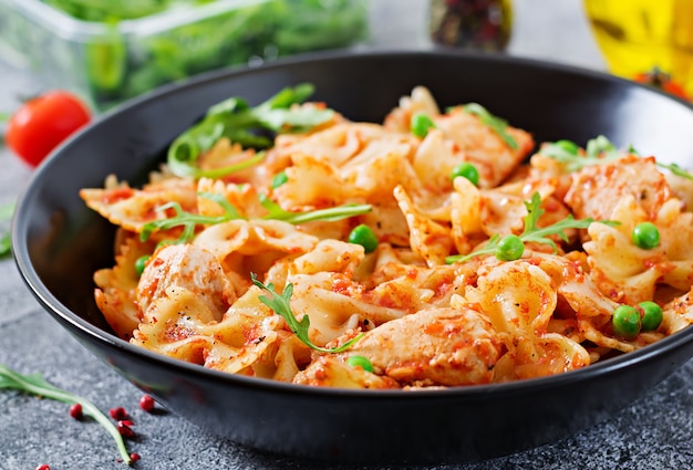 Pâtes farfalle au filet de poulet, sauce tomate et petits pois verts. Le menu