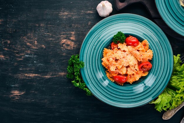 Pâtes Farfalle aux tomates et au parmesan Cuisine italienne Sur fond de bois Vue de dessus Espace de copie