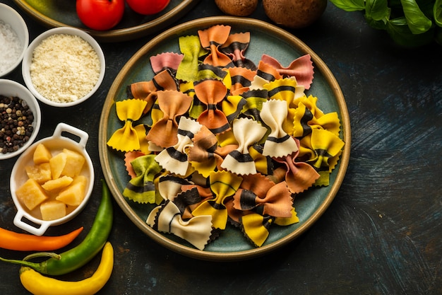 Pâtes farfalle non cuites, avec un ensemble de produits et ingrédients pour cuisiner des plats italiens traditionnels