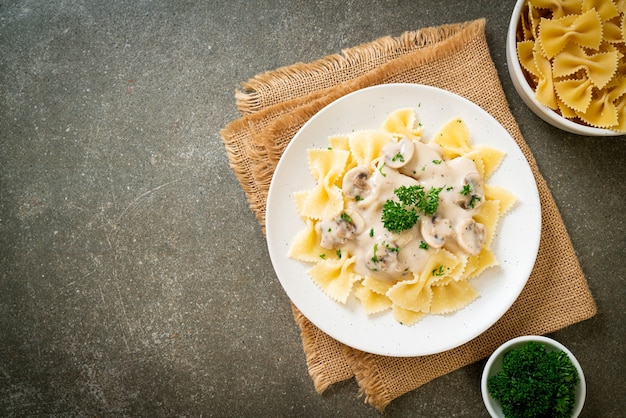 pâtes farfalle avec sauce à la crème blanche aux champignons - style cuisine italienne