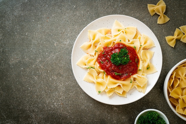 Photo pâtes farfalle à la sauce tomate avec persil - style cuisine italienne