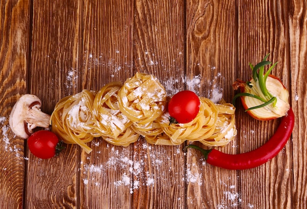 Pâtes et farine sur une surface en bois