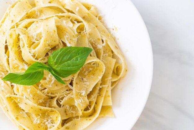 pâtes fettuccine au pesto avec du parmesan sur le dessus - style cuisine italienne