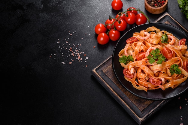 Pâtes fettuccine aux crevettes, tomates cerises, sauce, épices et herbes