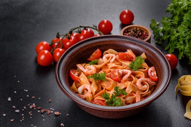 Pâtes fettuccine aux crevettes, tomates cerises, sauce, épices et herbes