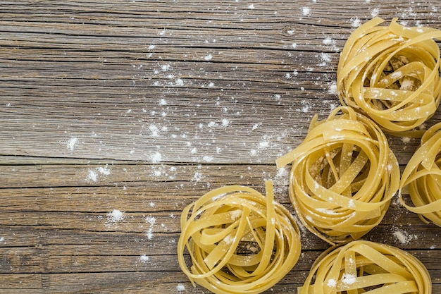 Pâtes fettuccine crues sur table en bois