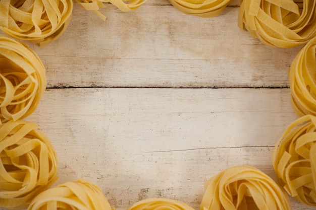 Pâtes fettuccine isolé sur table en bois