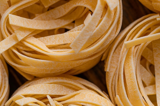 Pâtes fettuccine maison pliées en forme de nid Cuisine maison avec des ingrédients pour les pâtes fettuccine italiennes traditionnelles faites maison