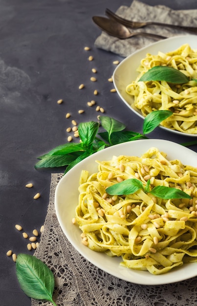 Pâtes fettuccine avec sauce pesto basilic et pignons de pin sur fond de béton cuisine italienne