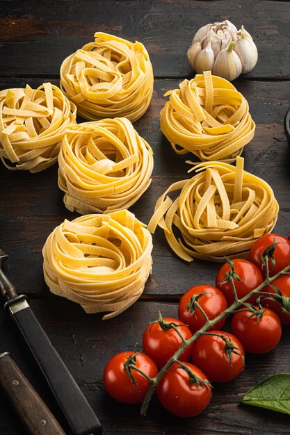 Pâtes fettuccine tagliatelles ingrédients alimentaires italiens sur fond de table en bois foncé ancien