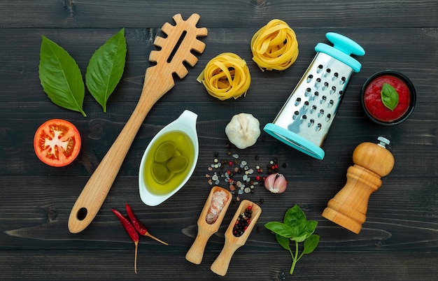 Les pâtes sur fond de bois noir Pâtes italiennes jaunes avec des ingrédients Cuisine italienne et concept de menu