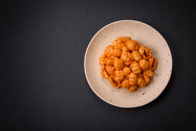 Des pâtes fraîches délicieuses avec de la sauce pesto, du sel, des épices et des herbes sur une assiette en céramique