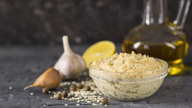 Pâtes fraîches tahini de graines de sésame avec de l'huile d'olive et du jus de citron sur une table en bois noire