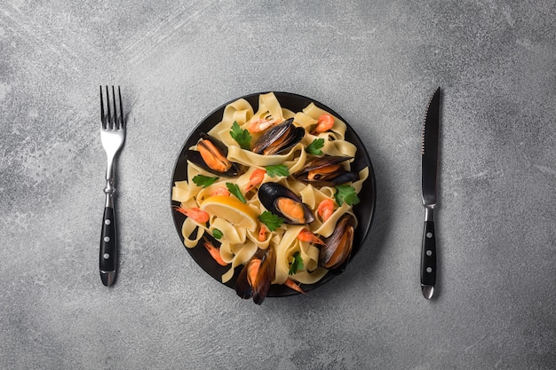 Pâtes de fruits de mer italiens traditionnels aux palourdes Spaghetti alle Vongole sur fond de pierre avec crevettes et moules