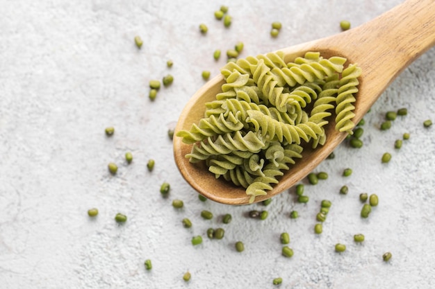 Pâtes fusilli aux haricots mungo sur fond de béton gris