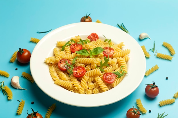 Pâtes fusilli aux tomates, herbes et basilic sur une assiette blanche