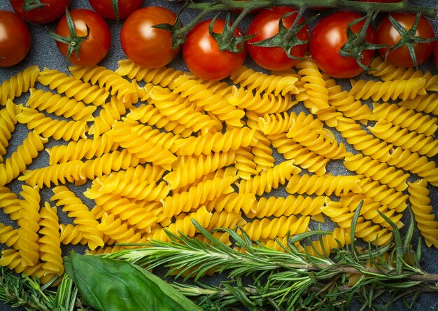 Pâtes fusilli crues aux tomates, herbes et basilic. Pâtes italiennes avec des ingrédients aux couleurs du drapeau italien