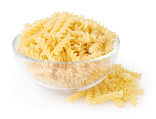 Pâtes fusilli non cuites dans un bol en verre isolé sur fond blanc