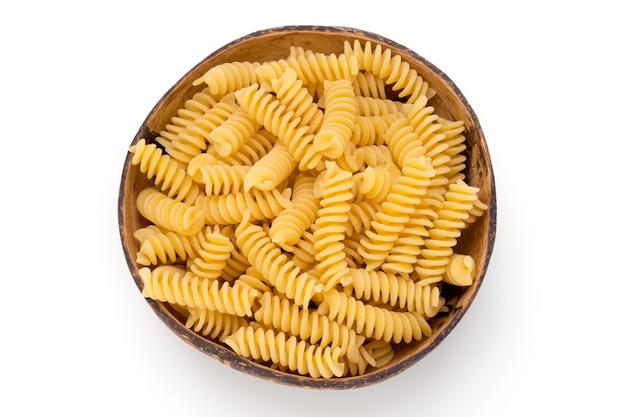 Pâtes fusilli non cuites fond blanc isolé.