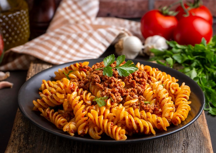 Photo pâtes fusilli, pâtes spirales ou spirales à la tomate, sauce hachée - style de cuisine italienne