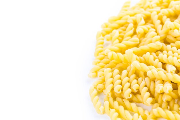 Pâtes gemelli jaune biologique sur fond blanc.