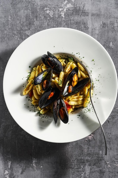 Pâtes gnocchetti sarde aux moules tomate et persil sur la table