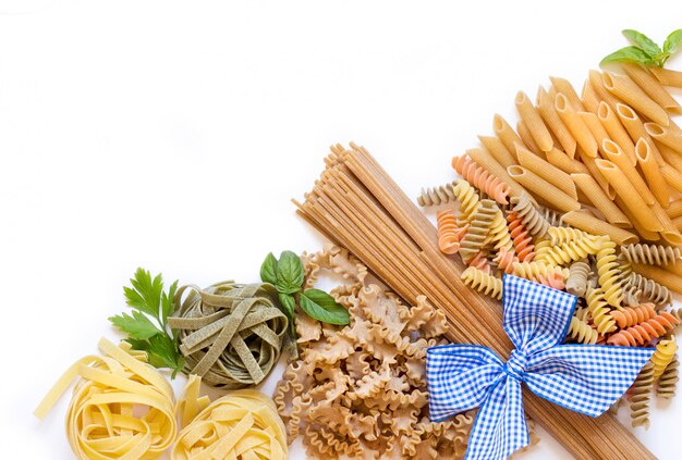 Photo pâtes italiennes au basilic et au persil sur fond blanc avec copie espace