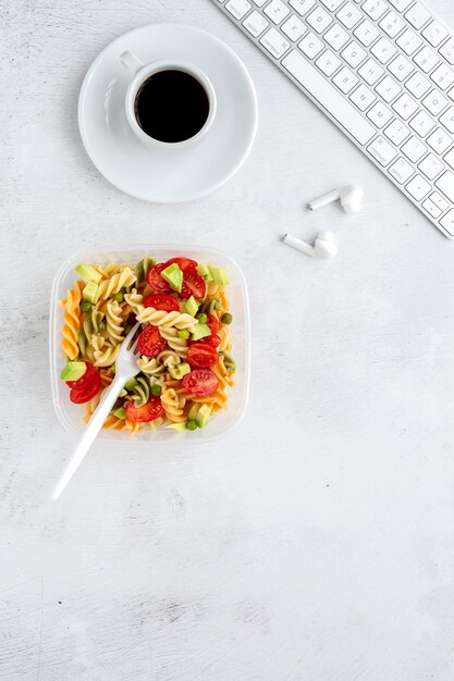 Pâtes italiennes aux légumes sur le bureau avec clavier