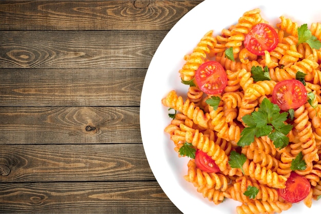 Pâtes italiennes aux tomates sur fond de bois