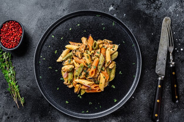 Pâtes italiennes de couleur Penne aux moules sur une assiette