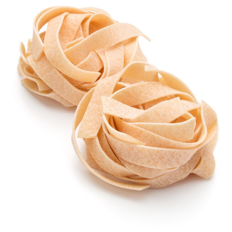 Photo pâtes italiennes fettuccine nid isolé sur fond blanc découpe